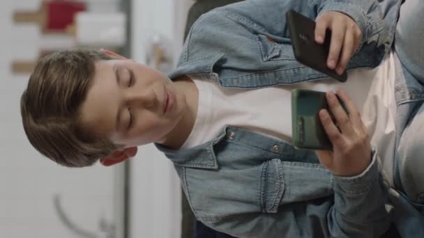 Menino Curioso Sentado Sofá Jogando Jogos Com Smartphones Menino Navegando — Vídeo de Stock