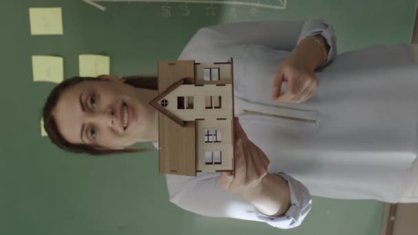 女性经纪人在图形板前面向销售团队或客户解释模型房 卖家展示了这个模型 并建议人们买房子 新的建设项目概念 — 图库视频影像