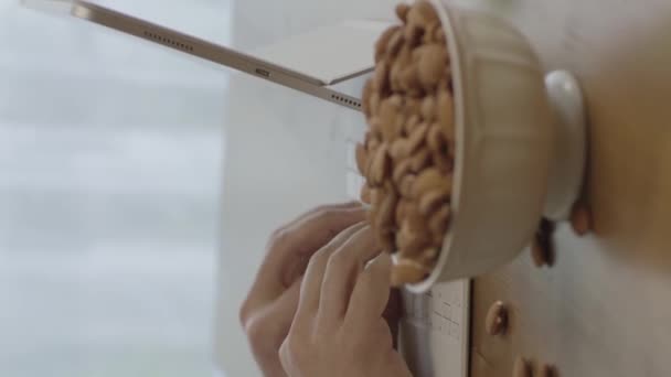 Freelance Man Drinks Coffee Eats Roasted Almonds Hazelnuts Cookies While — Stok video