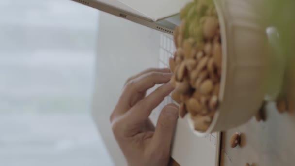 Freelance Man Drinks Coffee Eats Roasted Almonds Hazelnuts Cookies While — Vídeo de Stock