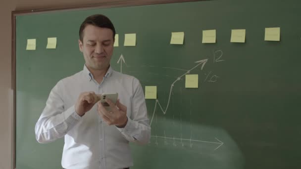 Male Teacher Front Blackboard Looking Information Phone Searching Something Internet — Video