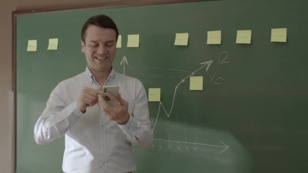 Male Teacher Front Blackboard Looking Information Phone Searching Something Internet — Stok video