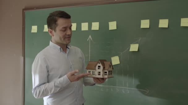 Male Real Estate Agent Explaining Model House Sales Team Front — Stockvideo