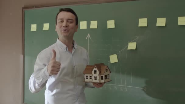 Male Real Estate Agent Explaining Model House Sales Team Front — Stockvideo