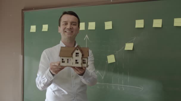 Male Real Estate Agent Explaining Model House Sales Team Front — Vídeo de Stock