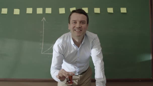 黒板の前に立つ男性教師は メモやチョークで数式を描き カメラで微笑み 生徒たちに教えていた オンライン距離教育 — ストック動画