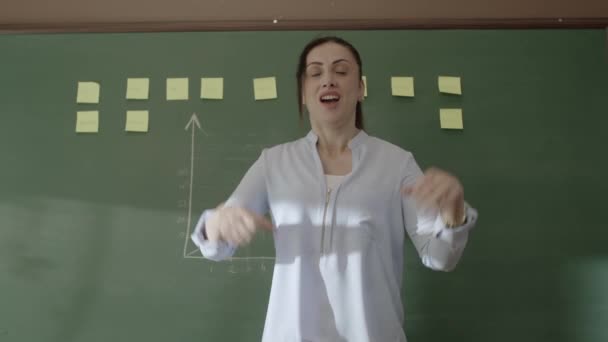 Γυναίκα Δασκάλα Στέκεται Μπροστά Στον Πίνακα Κολλημένες Νότες Και Κιμωλίες — Αρχείο Βίντεο