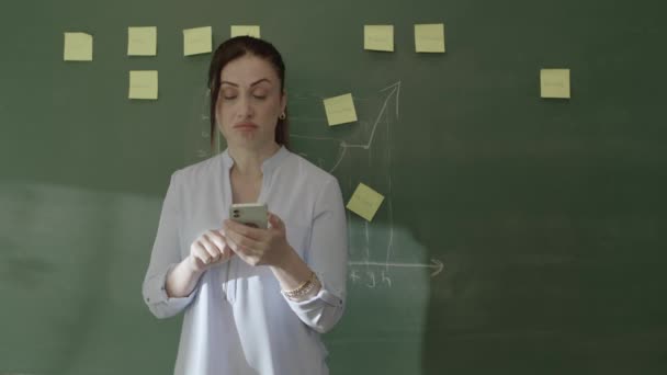 Ung Kvinnlig Lärare Klassrummet Bläddra Sociala Medier Konton Sin Smartphone — Stockvideo
