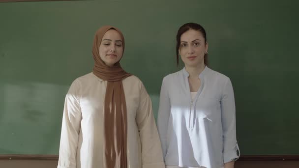 Учительница Хиджабе Коллега Женщина Смотрящая Камеру Классе Руками Перед Доской — стоковое видео