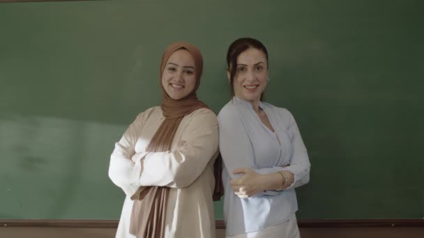 Female Teacher Hijab Female Colleague Classroom Arms Folded Front Blackboard — Stockvideo