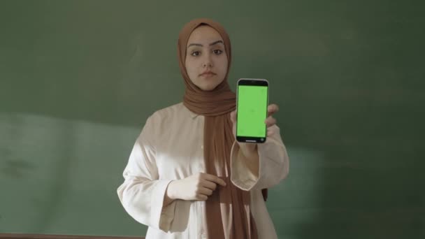 Классе Учительница Хиджабе Смотрит Аккаунты Социальных Сетях Своего Смартфона Просматривает — стоковое видео