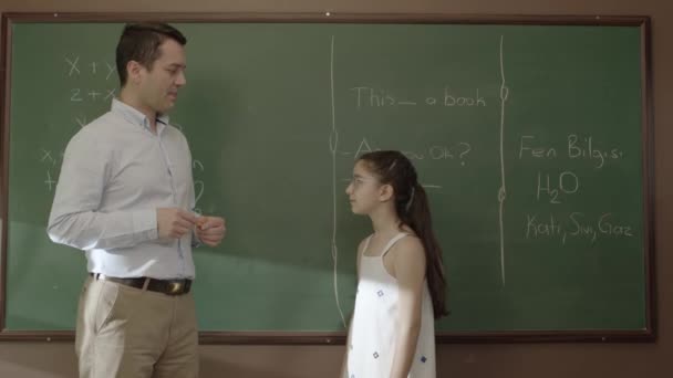 教室の黒板で女学生に数学を教える若い先生 彼女の学生が試験の準備と成功を支援したい理想的な教師の肖像画 成功した先生 — ストック動画