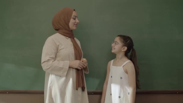 Læreren Hijab Underviser Den Studerende Foran Tavlen Lille Skolepige Iført – Stock-video