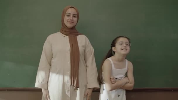 Маленькая Школьница Учительница Хиджабе Смотрят Камеру Классе Улыбаются Перед Доской — стоковое видео