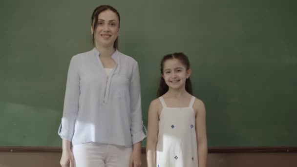 Счастливый Учитель Маленькая Школьница Стоят Перед Доской Классе Сложенными Руками — стоковое видео