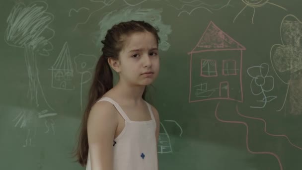 少女はボード上の問題を解決できないことに動揺している 数学の練習の問題 悲しい女の子少し解決数学演習近くザ黒ボード — ストック動画