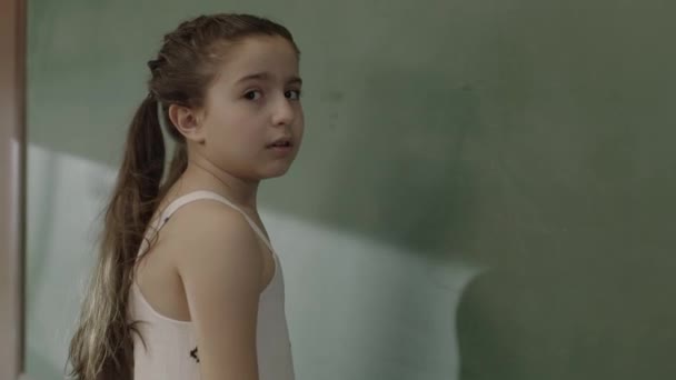 Little Sad Girl Standing Front Green Chalkboard Her School Little — Αρχείο Βίντεο