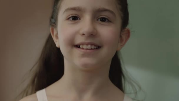这个小女孩的画像 小女孩高兴地看着摄像机 好奇的小女孩在绿色黑板前笑着 快乐童年和学习的概念 — 图库视频影像