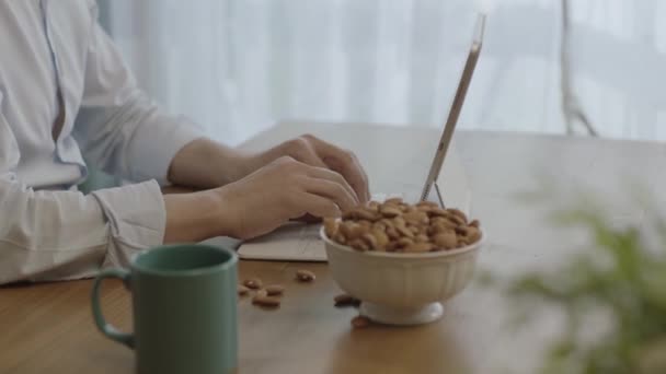 Freelance Man Drinks Coffee Eats Roasted Almonds Hazelnuts Cookies While — Stock video