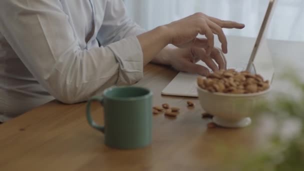 Freelance Man Drinks Coffee Eats Roasted Almonds Hazelnuts Cookies While — 비디오