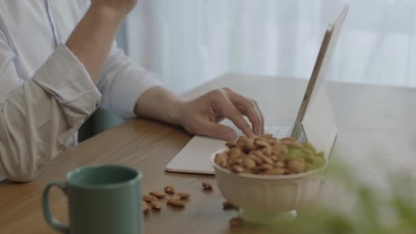 Freelance Man Drinking Coffee Eating Roasted Almonds Hazelnuts Cookies While — Stockvideo