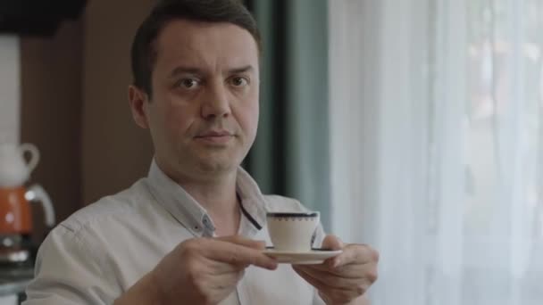 自宅で妻や友人にコーヒーを出す男 スローモーションで働く男 コーヒー休憩 トルコのコーヒーをゲストに提供しながら流出しないようにしようとしている男のクローズアップ手 — ストック動画