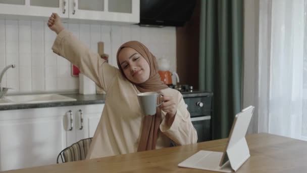 Young Woman Hijab Works Remotely Tablet Computer Woman Drinks Coffee — Stock Video