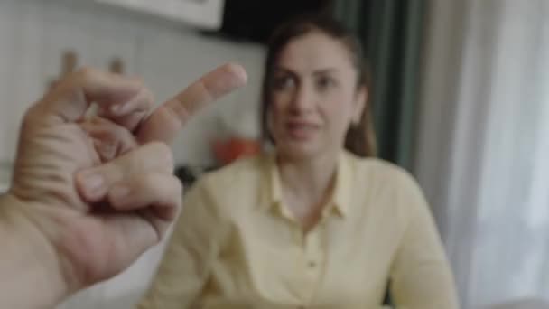 台所で女友達とおしゃべりをしていると カメラの後ろにある中指が怒りを表している コンピュータカメラから見た女性の姿 — ストック動画