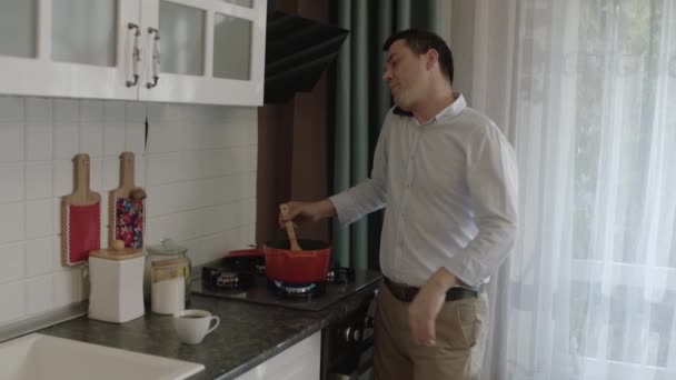 Young Single Man Preparing Food Kitchen Talking Cell Phone Same — Stock Video