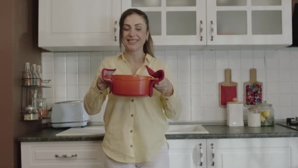 Young Mother Smells Food She Prepared Her Kitchen Puts Pot — Vídeo de Stock
