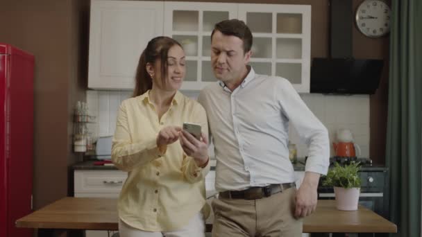 Happy Couple Using Smartphone Dining Table Kitchen Checking Bank Accounts — Vídeo de Stock