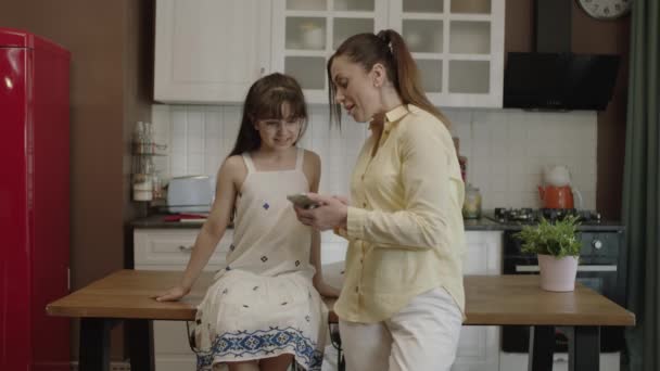 Happy Mother Her Little Daughter Using Smartphone Dinner Table Kitchen — Vídeo de stock
