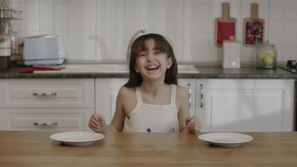 Милая Маленькая Девочка Ждет Свою Еду Кухонным Столом Удивлена Глядя — стоковое видео