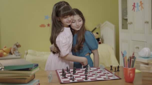 スマート女の子たちの部屋でチェスをして お互いを愛し カメラで笑顔の肖像画 子供の論理的思考の発展 知性と知性だ 論理的思考を発達させるため — ストック動画