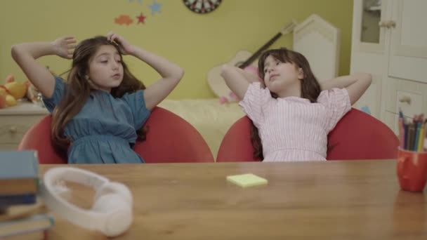 Μικρά Όμορφα Και Χαριτωμένα Κορίτσια Στα Λευκά Κάθονται Στο Τραπέζι — Αρχείο Βίντεο