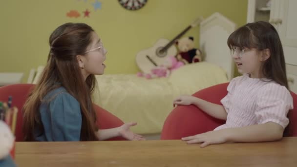 Szép Fehér Ruhás Kislányok Asztalnál Ülnek Gyerekszobájukban Beszélgetnek Szerető Lányok — Stock videók