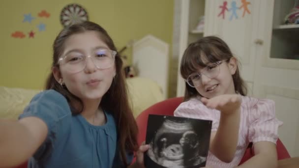 Little Girls Holding Image Unborn Sibling Ultrasound Girls Take Selfie — Stockvideo