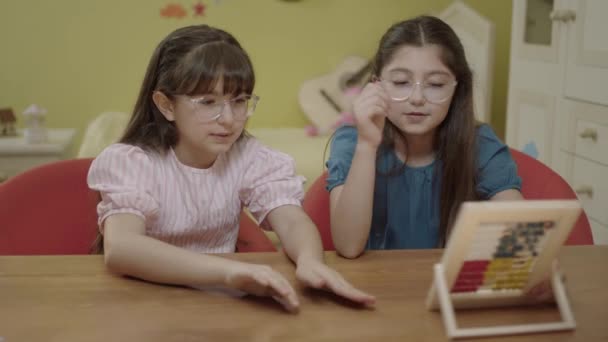 かわいいそろばんで遊んでいる女の子 家庭で木製のそろばんで遊ぶ子供たち 就学前のおもちゃで楽しんでいる子供たち — ストック動画