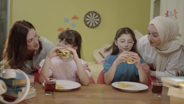 Moms Bringing Burgers Eat Little Girls Doing Schoolwork Veiled Mother — Vídeo de Stock