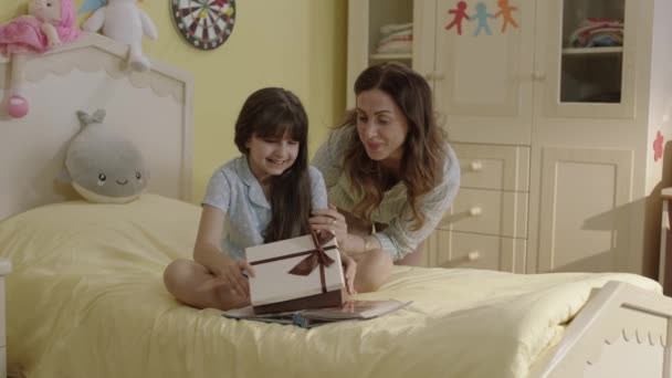 Mother Giving Birthday Present Her Daughter Sitting Her Bed Her — Vídeo de stock