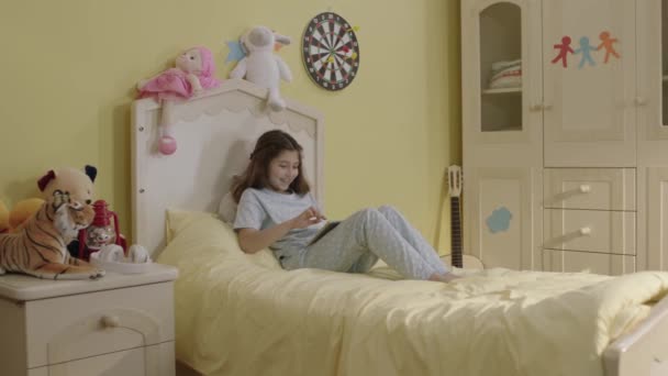 Lille Pige Spiller Online Spil Tablet Computer Hendes Seng Fortsætter – Stock-video