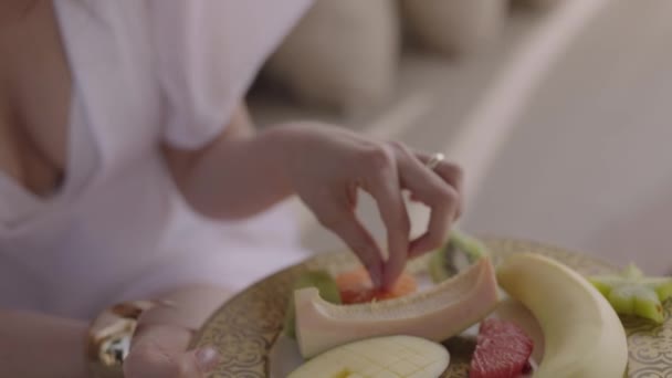 Woman White Dress Vacation Holds Plate Fruit Woman Eats Red — Vídeo de stock