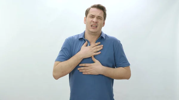 Sick, unhealthy heart and man with painful cramp in his stomach is squeezing his stomach and suffering from severe heart pain.Man in his 30s strong chest pain,heart attack caused by stress,cardiology.