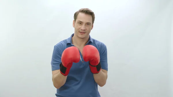 Coping with difficulties in business life. Young man with boxing gloves isolated on white background. Young man is exercising with boxing. Punch. Strong man portrait.