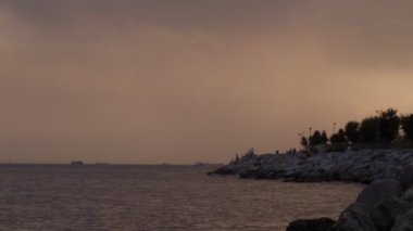 People fishing with fishing rods on rocks by the sea at sunset.A wonderful aerial panoramic view of a fisherman fishing by the sea.