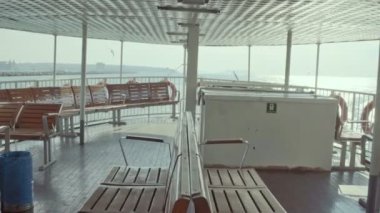 Empty seats on the ferry passing from skdar Istanbul to Beikta during the Covid-19 curfew.Wooden empty steamer seat with sea view in open space.