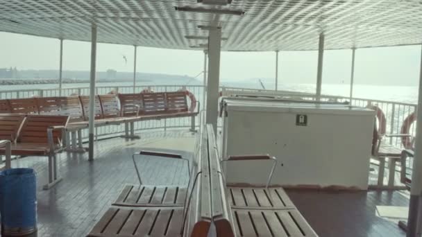 コヴィッド 19カーフの間にイスタンブールから北京に渡るフェリーの空の座席オープンスペースで海の景色を望む木製の空のスチーマーシート — ストック動画