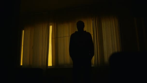 暗い部屋に閉じられた窓の前に立っている心配そうな男 落ち込んでいる人 — ストック動画