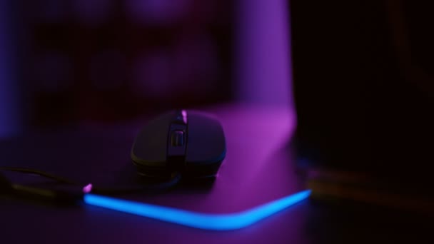 ライトアップマウスを使用してビデオゲームをプレイゲーマーのクローズアップ手 マウスを使用して男性の手 ネオンライトの背景 — ストック動画