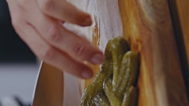 台所の木製の床に小さな漬物キュウリを切断女性のクローズアップ手 女は台所でキュウリを切っている サンドイッチを作るためにキュウリをカット — ストック動画